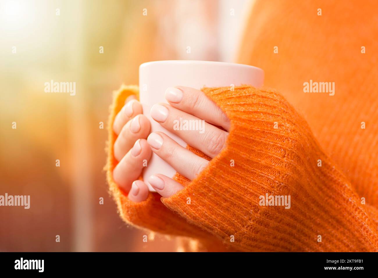 A woman drinks coffee at home with the sunrise through the window Stock ...