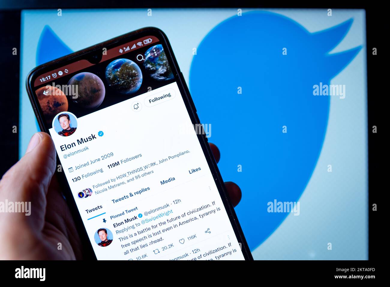 In this photo illustration, Billionaire entrepreneur Elon Musk's Twitter page seen displayed on a smartphone and  the Twitter logo in the background. Stock Photo