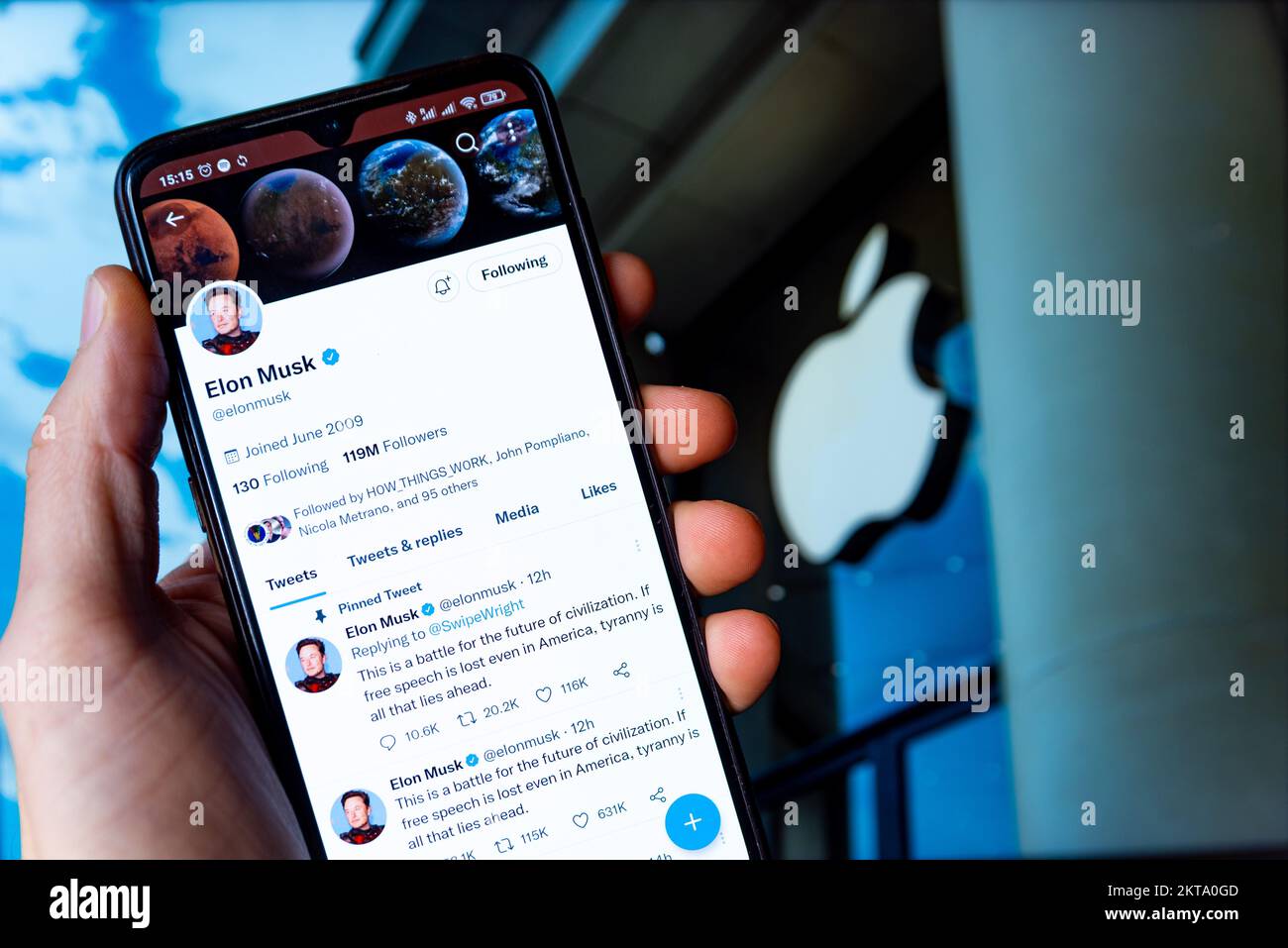 In this photo illustration, Billionaire entrepreneur Elon Musk's Twitter page seen displayed on a smartphone and the Apple logo in the background. Stock Photo