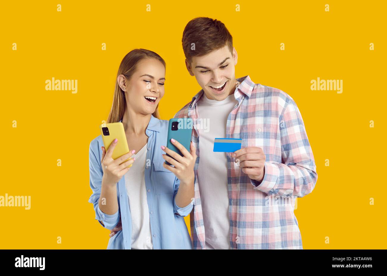 Happy young couple use smartphone and credit card for online purchases and payments Stock Photo