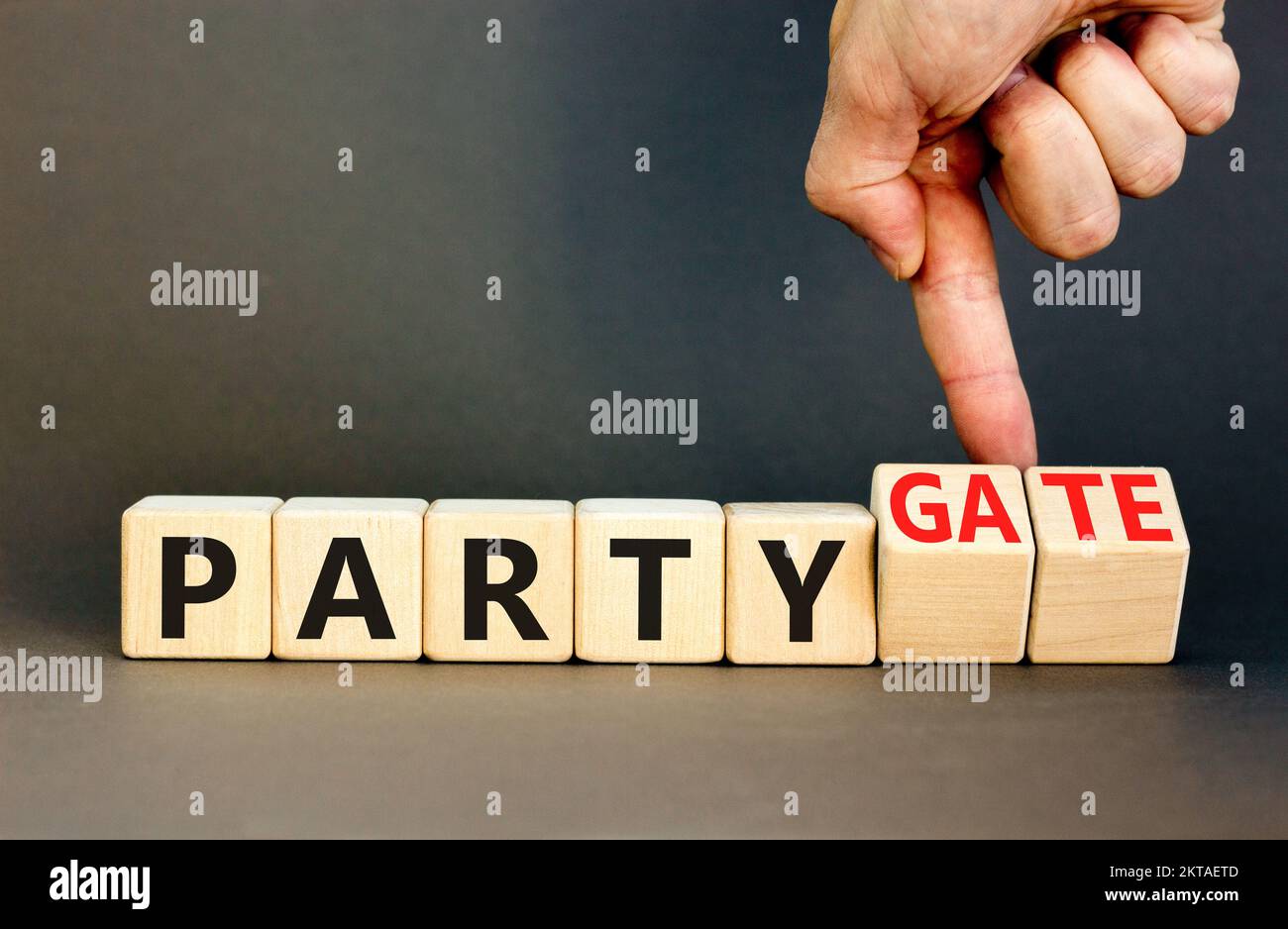 Party and partygate symbol. Concept words Party and Partygate on wooden cubes. Businessman hand. Beautiful grey table grey background. Business party Stock Photo