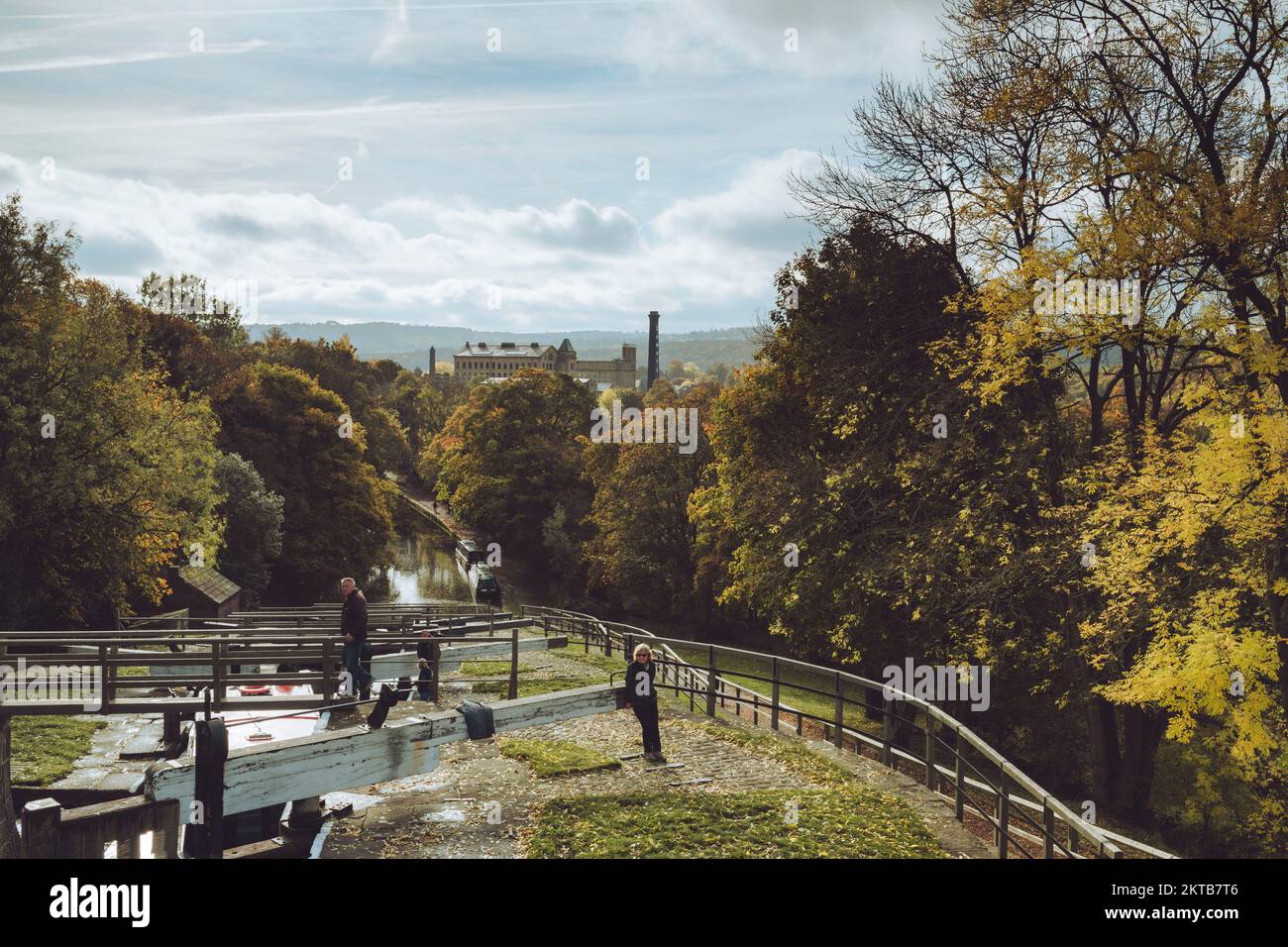 2 people by lock gates (opening gate) boats moored & sunlit Damart mill