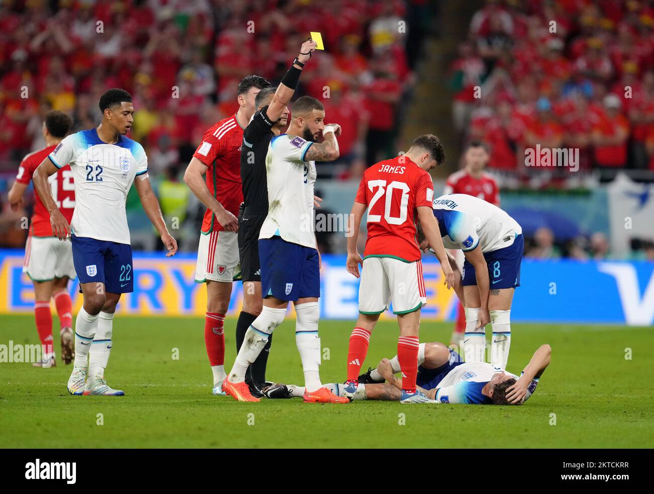 Wales' Daniel James is shown a yellow card for a challenge on England's John Stones (on floor) during the FIFA World Cup Group B match at the Ahmad Bin Ali Stadium, Al Rayyan, Qatar. Picture date: Tuesday November 29, 2022. Stock Photo