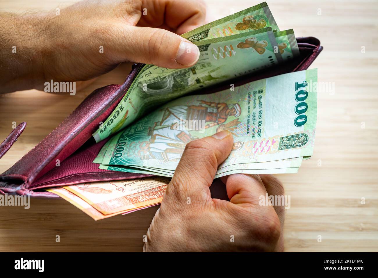 Hand takes out money from wallet, Sri Lanka Banknotes, Economic concept, rising prices, Low value of Sri Lanka Rupee Stock Photo
