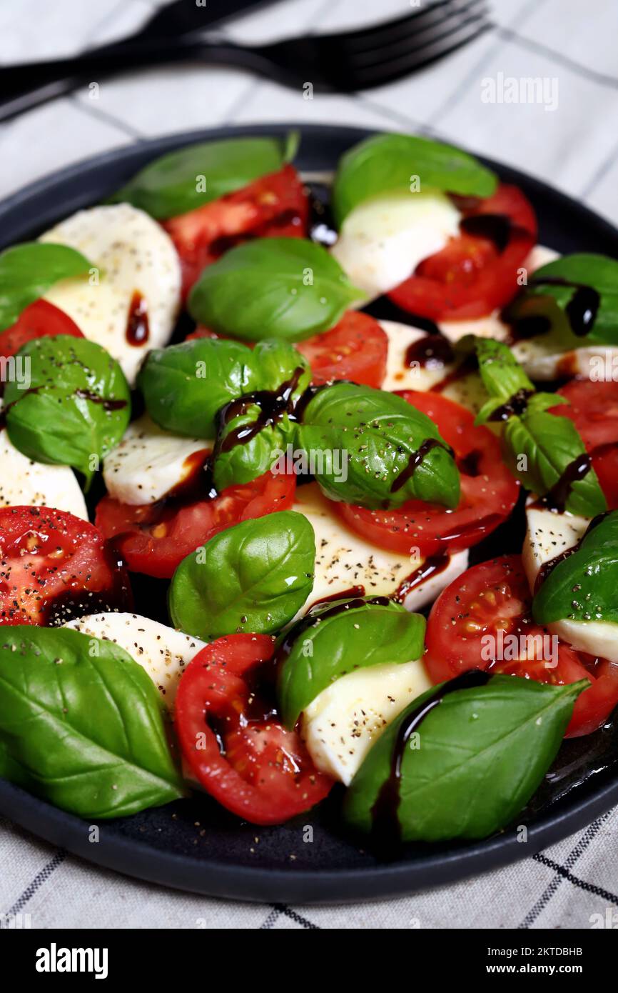 Italian signature caprese salad on a black plate. Stock Photo