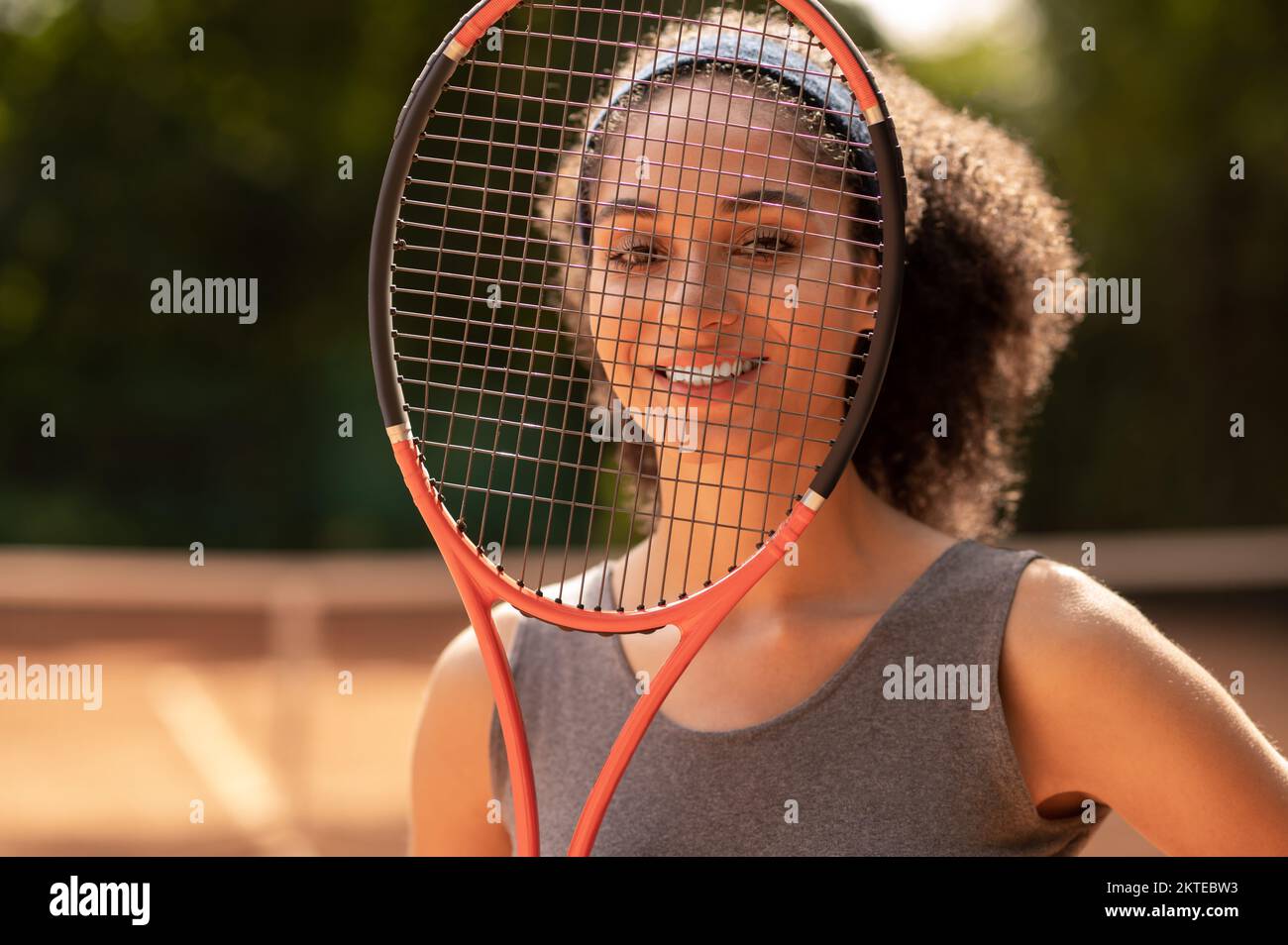 Smiling cute female tennis player with a racket in hands Stock Photo