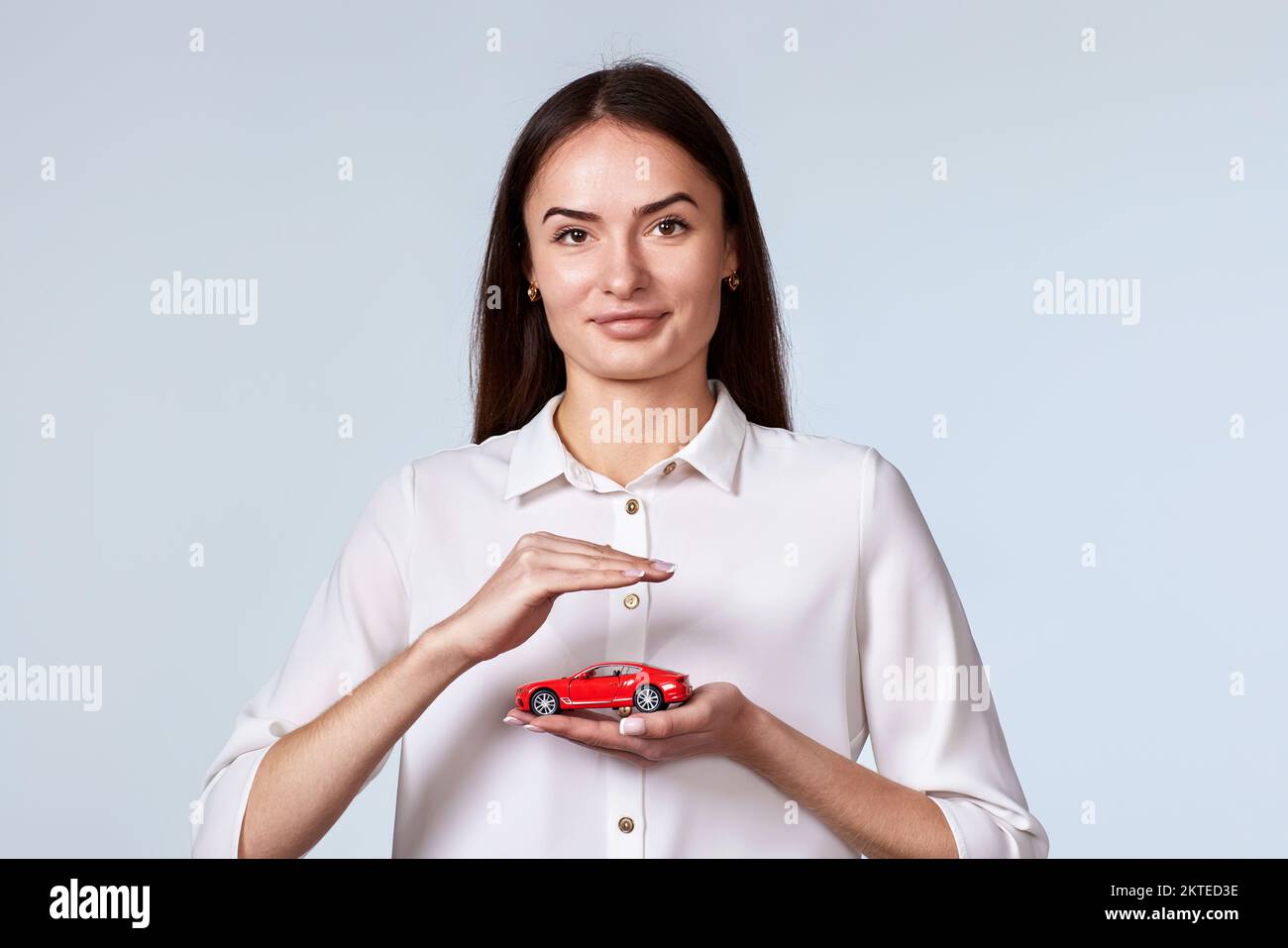 beautiful woman in white shirt holding little red car Stock Photo - Alamy