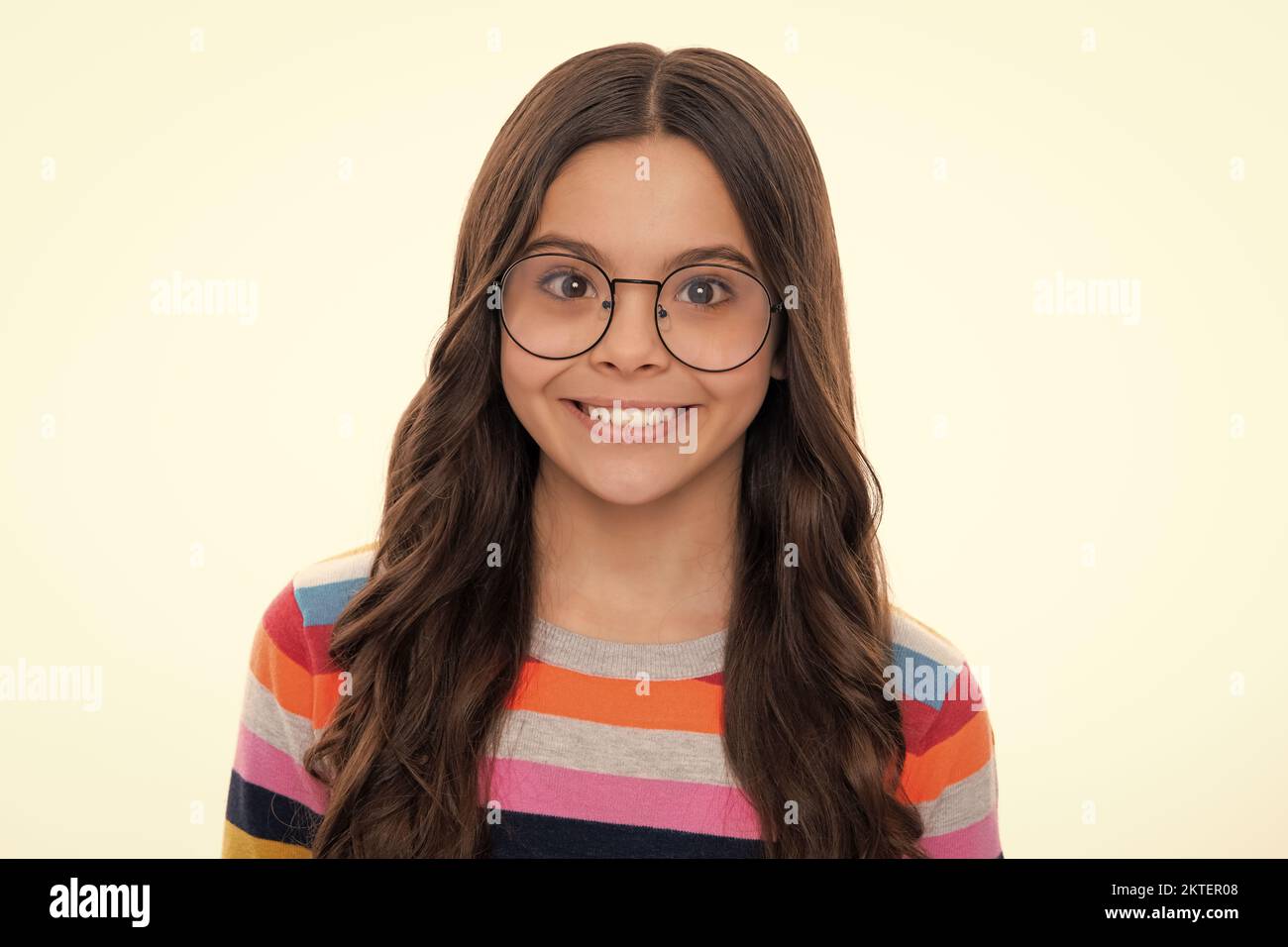 Close up portrait of caucasian teen girl. Head shot of cute teenager child on yellow isolated