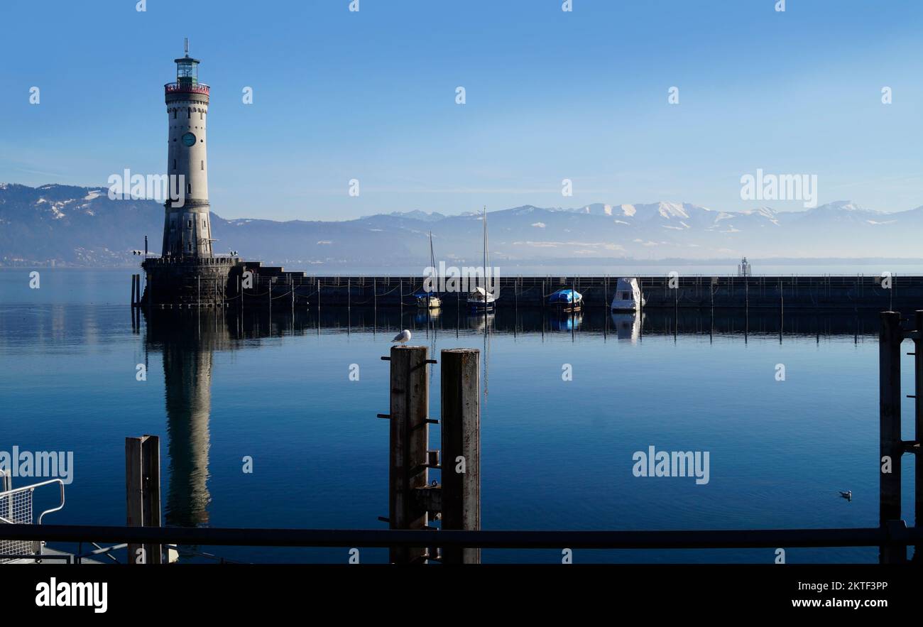 harbour of Lindau on tranquil wintery lake Constance or lake Bodensee with the Alps in the background on a fine winter evening with the scenic sky Stock Photo