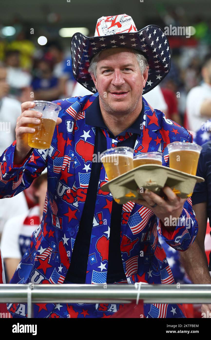 Doha, Qatar. 29th Nov, 2022. A USA fan looks on holding a tray of beers