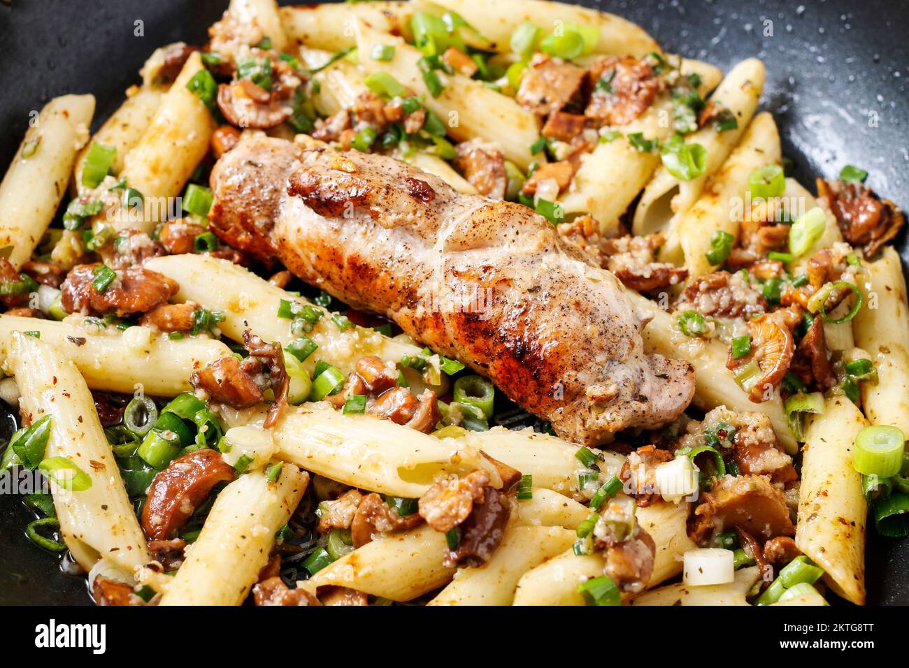 Baked pork chop with penne pasta. Italian cuisine recipe Stock Photo