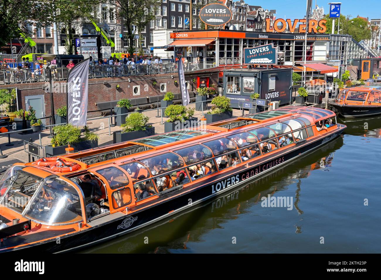 Amsterdam, Netherlands - August 2022:  People on a canal boat waiting to leave the jetty on a city sightseeing trip  operated by the Lovers company Stock Photo