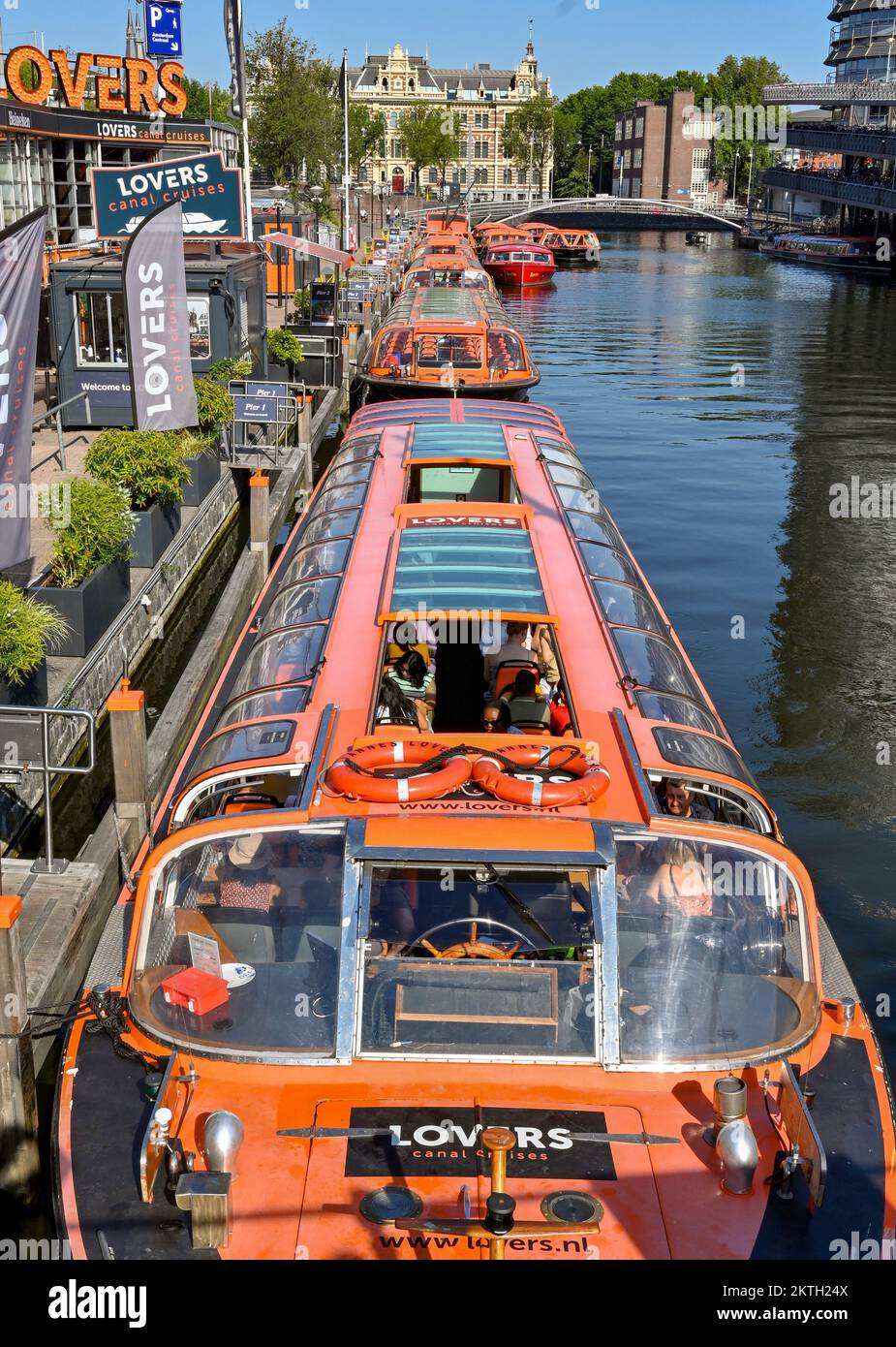Amsterdam, Netherlands - August 2022:  People on a canal boat waiting to leave the jetty on a city sightseeing trip operated by the Lovers company Stock Photo