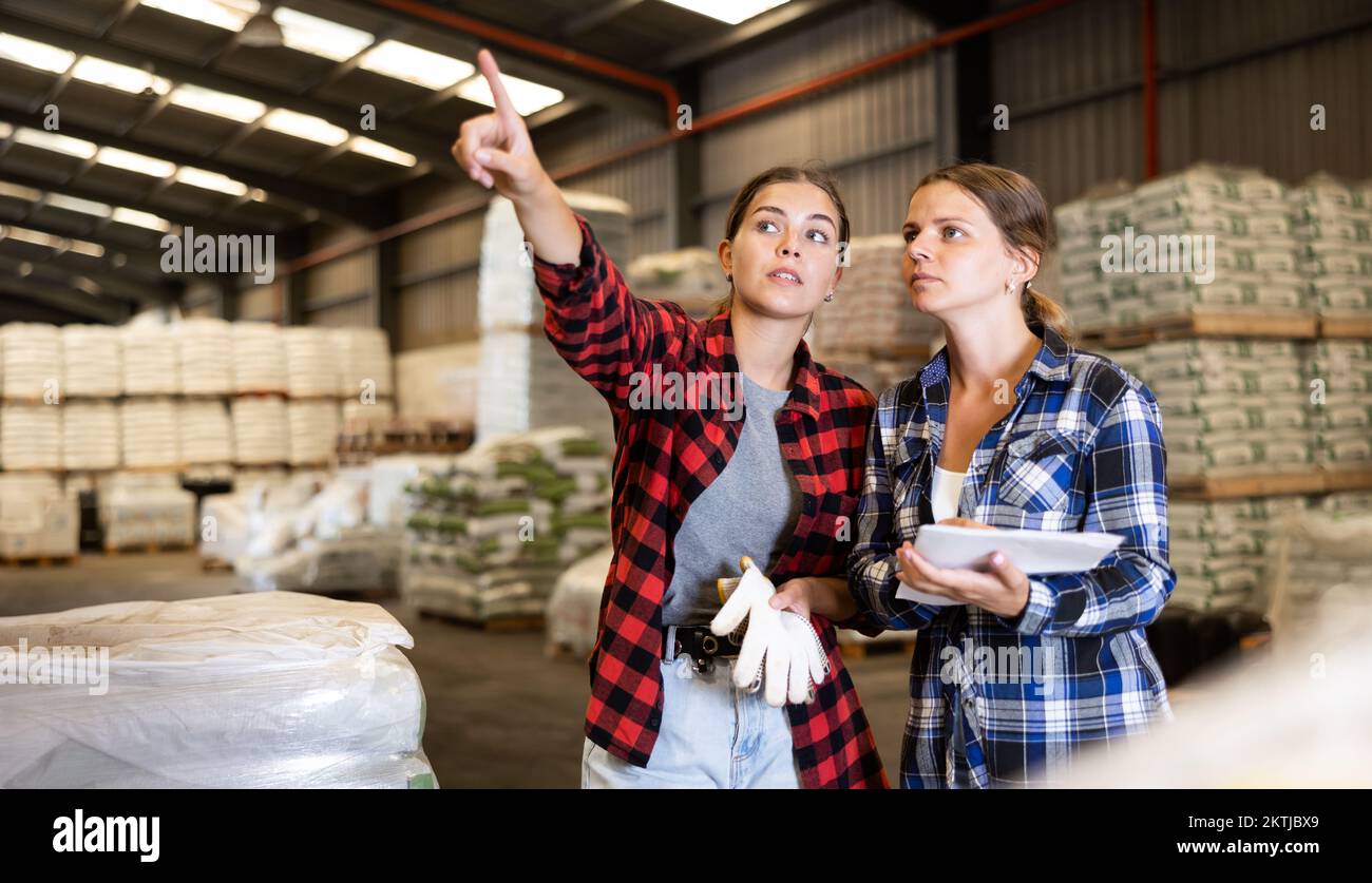 Female warehouse owner and manager keep track of products in warehouse