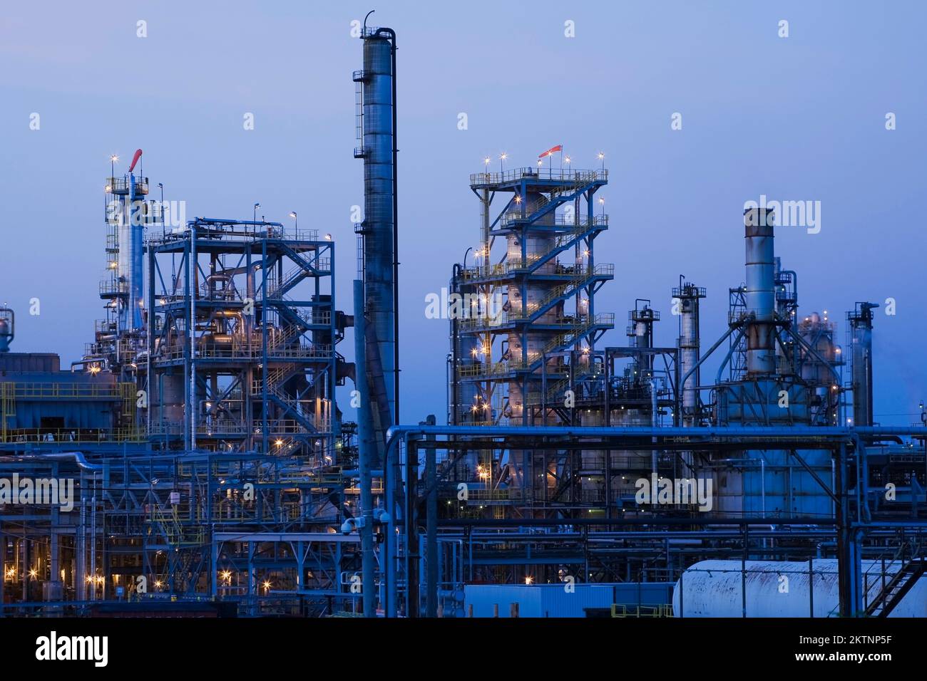 Storage tank and towers at oil and gas refinery at dusk Stock Photo - Alamy