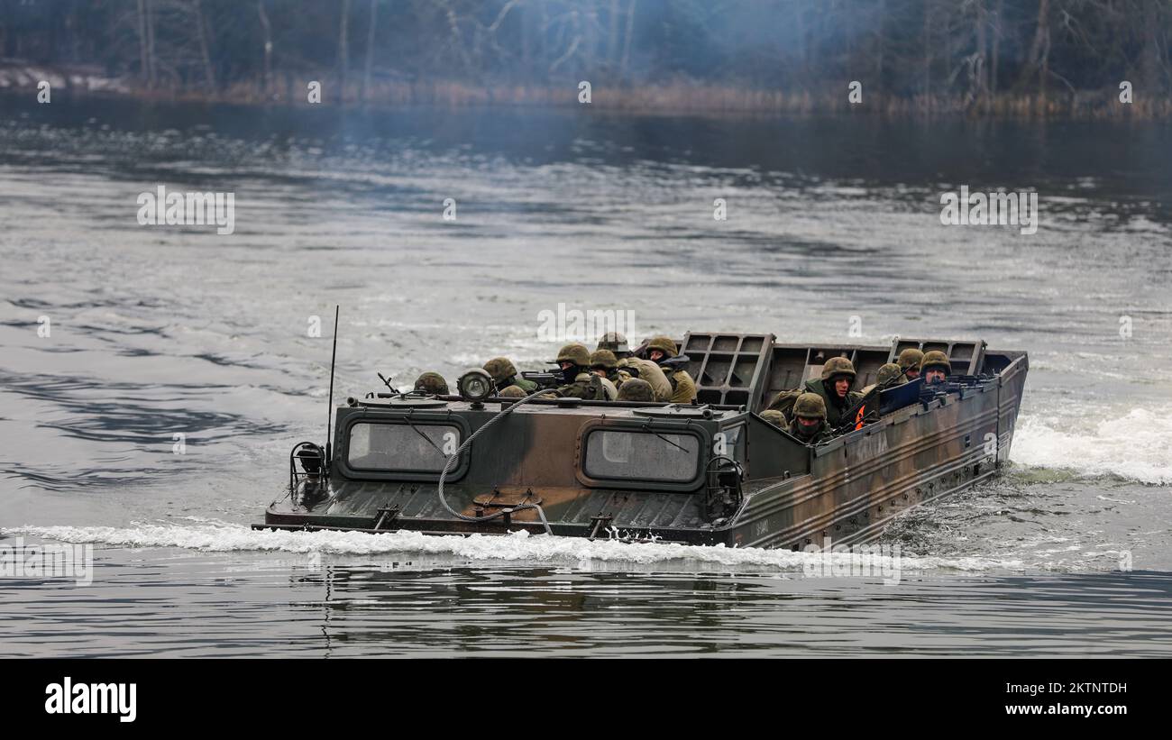 Polish soldiers assigned to 20th Mechanized Brigade utilize a PTS-Medium Amphibious Transport to ferry infantry soldiers across a lake while conducting amphibious assault operations during the Bull Run training exercise at Bemowo Piskie, Poland, Nov. 25, 2022. The 20th Mechanized Brigade is proudly working alongside the 1st Infantry Division, NATO allies and regional security partners to provide combat-credible forces to V Corps, under America's forward deployed corps in Europe. (U.S. Army National Guard photo by Sgt. Gavin K. Ching) Stock Photo