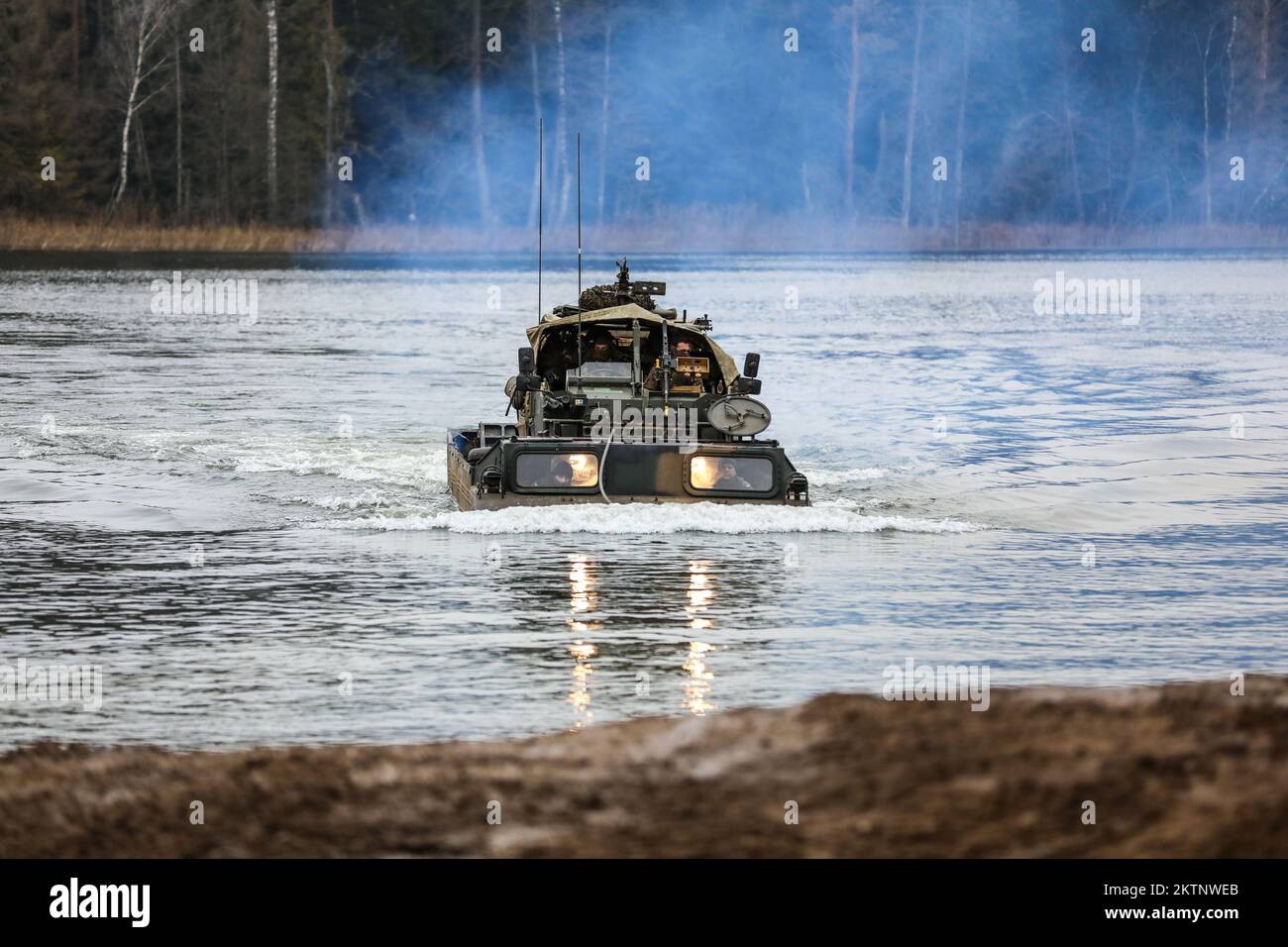 Polish soldiers assigned to the 20th Mechanized Brigade utilize an Army Medium Amphibious Transport to carry a U.K. Royal Lancers, Prince of Wales Troop 2A Mobility Weapon-Mounted Installation Kit vehicle across a lake while conducting amphibious assault operations during the Bull Run training exercise at Bemowo Piskie, Poland, Nov. 24, 2022. The 20th Mechanized Brigade is proudly working alongside the 1st Infantry Division, NATO allies and regional security partners to provide combat-credible forces to V Corps, under America's forward deployed corps in Europe. (U.S. Army National Guard photo Stock Photo