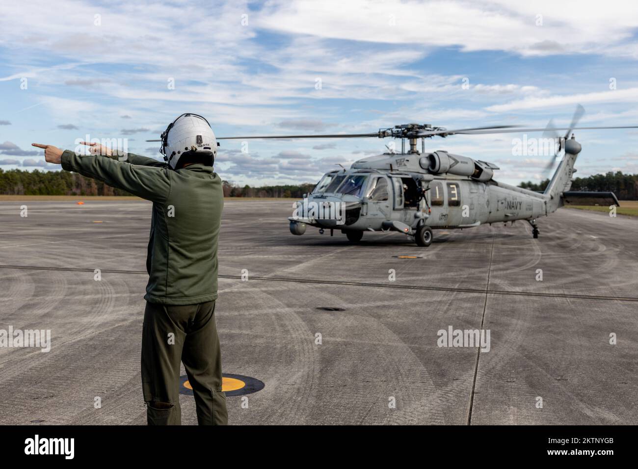 A U.S. Marine with Marine Aerial Refueler Transport Squadron (VMGR) 252 directs a U.S. Navy MH-60S Seahawk to the air-delivered ground-refueling point at Blackstone Army Airfield, Virginia, Nov. 16, 2022. VMGR-252 provided assault support to Naval Special Warfare Group 2 during Exercise Trident 23-2 to enhance combat readiness and improve naval integration. VMGR-252 is a subordinate unit of 2nd Marine Aircraft Wing, the aviation combat element of II Marine Expeditionary Force. (U.S. Marine Corps photo by Cpl. Caleb Stelter) Stock Photo