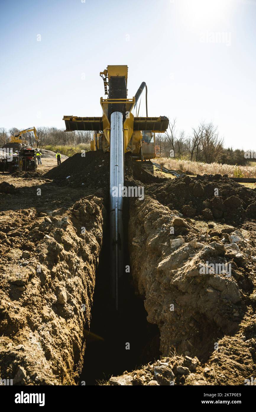 A DeWind construction worker uses the trencher Nov. 21 to dig a 30-foot-deep trench at Wright-Patterson Air Force Base, Ohio. The trencher digs, lays the pipe and fills the trench in one efficient and environmentally friendly pass. (U.S. Air Force photo by Hannah Carranza) Stock Photo