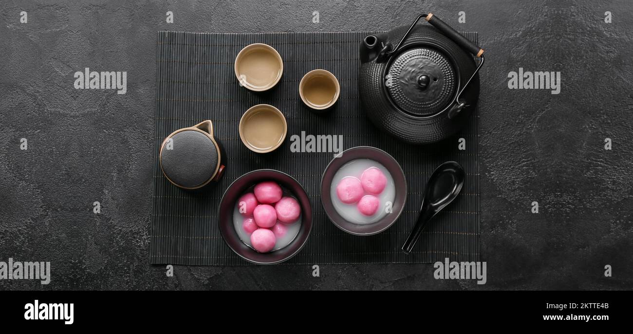 Bowls of tangyuan, cups and teapots on dark background. Dongzhi ...