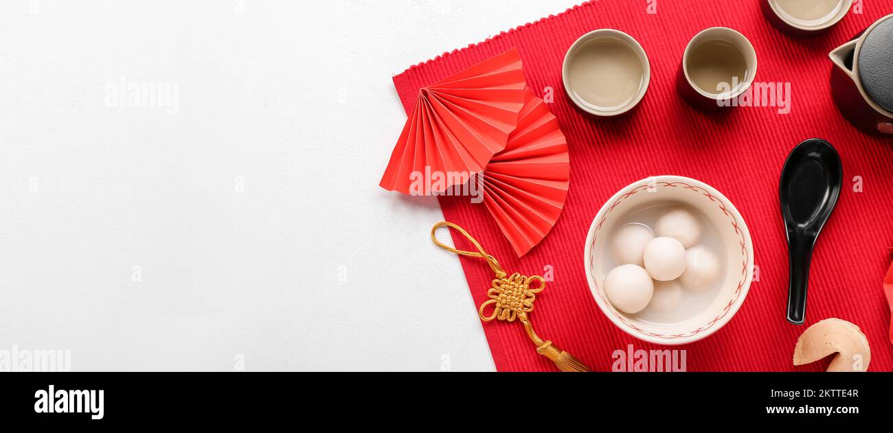 Bowl of tangyuan with tea and Chinese decor on white background with ...