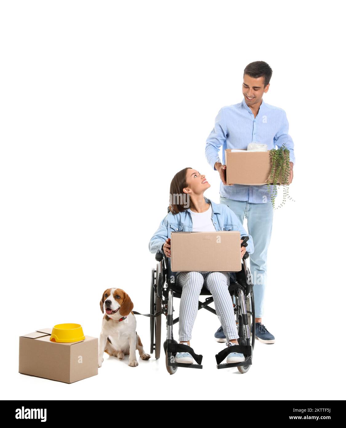 Young man with his wife in wheelchair, moving boxes and dog on white
