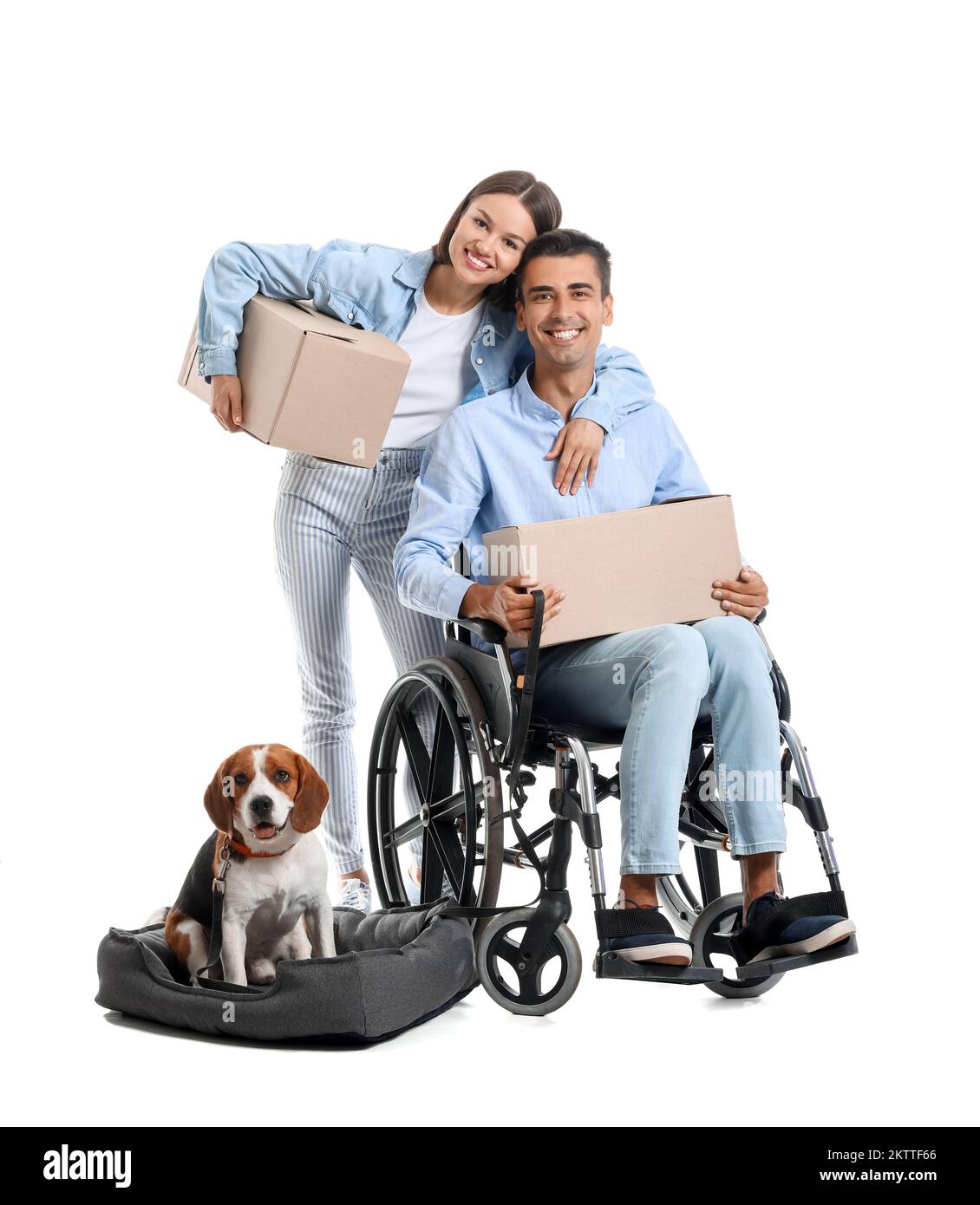 Young woman with her husband in wheelchair, moving boxes and dog on
