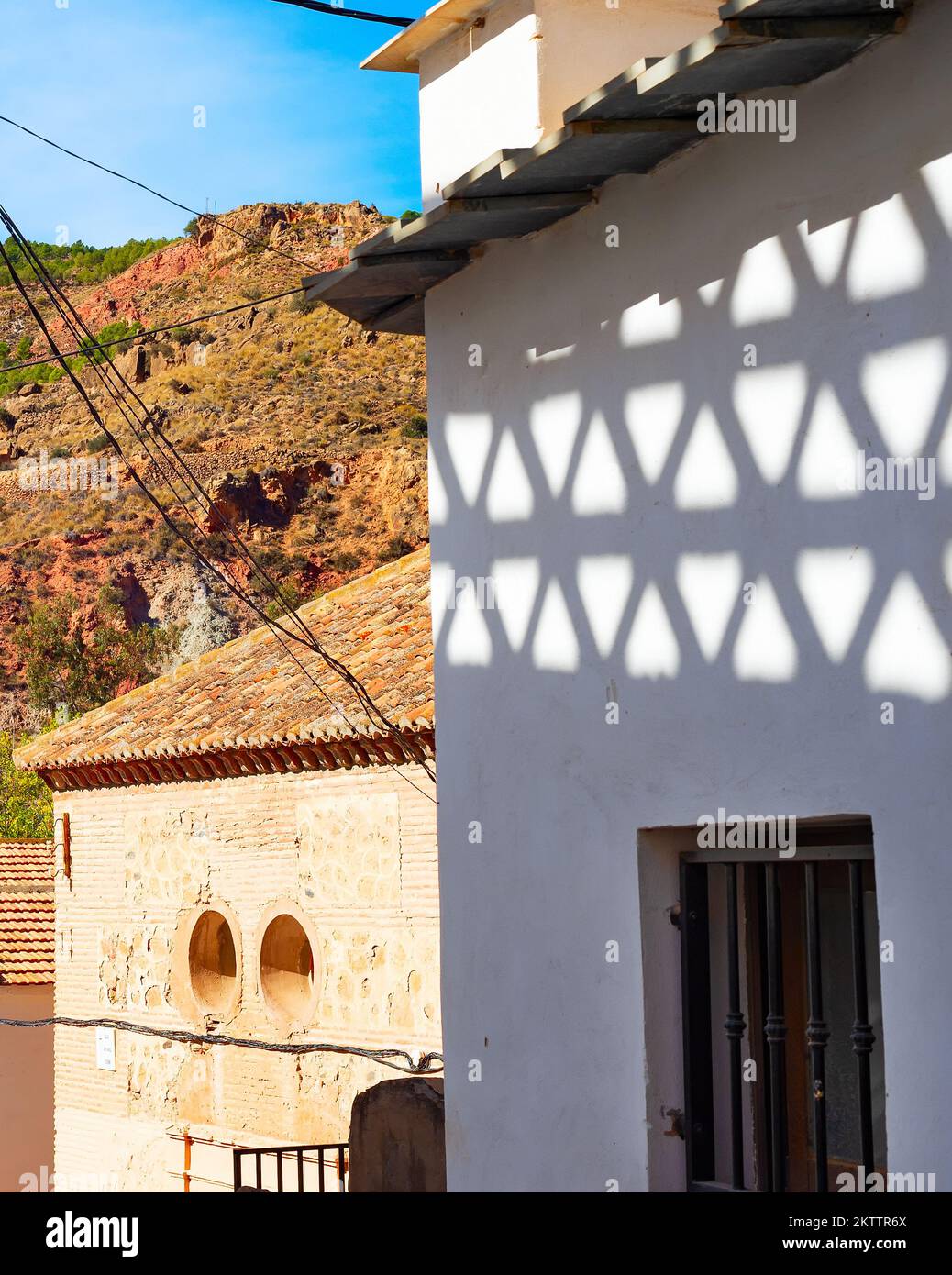 Street of an old mountain village in sunshine, shadows on wall, Cartagena, Spain Stock Photo