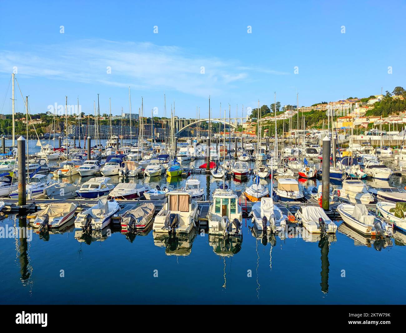 Marina with moored sailboats and yachts, reflection on water, sunhine evening, Arrabida bridge, Porto, Portugal Stock Photo