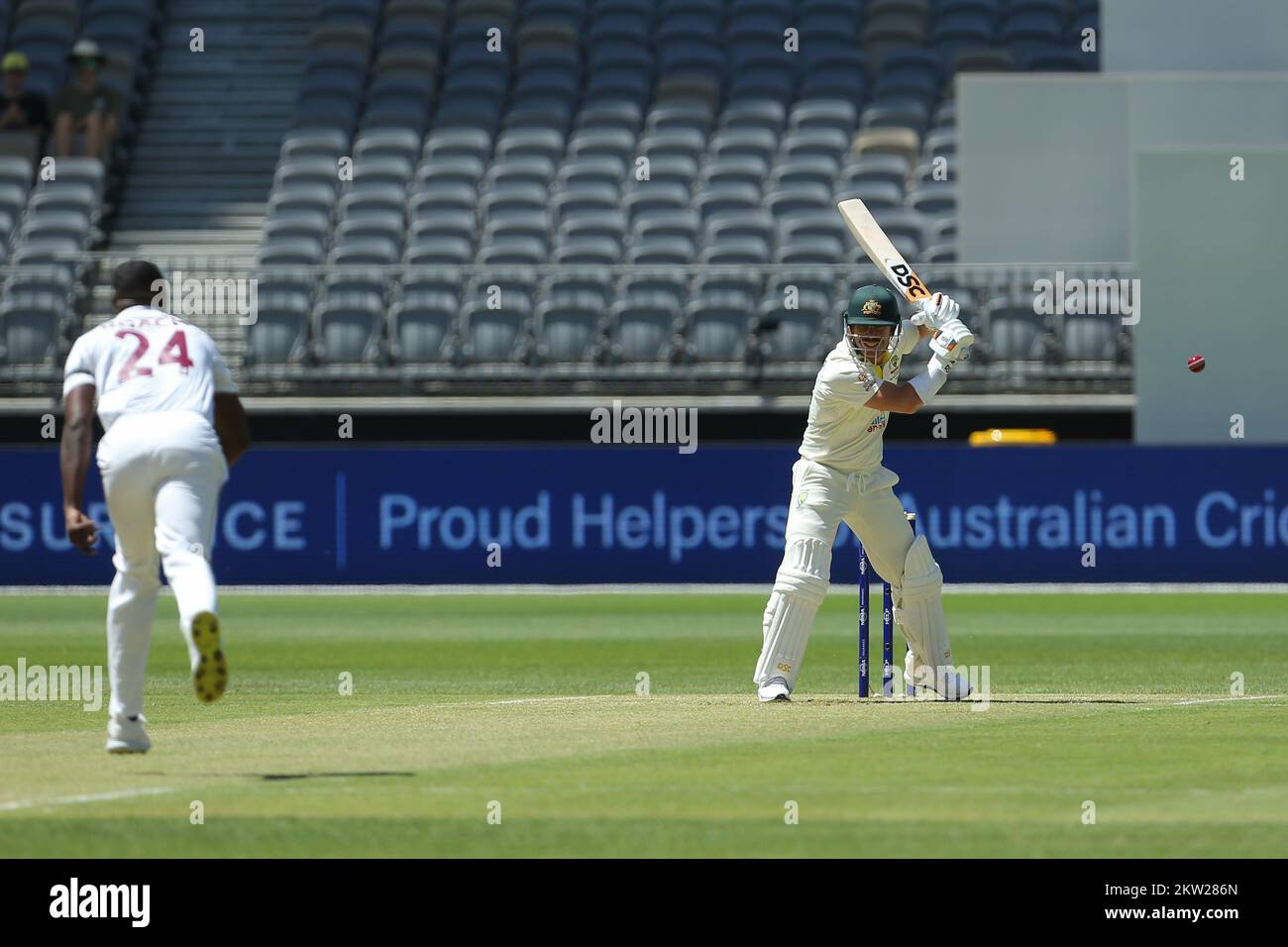 Optus Stadium, Perth, Australia: 30th November 2022,  International Test Cricket Australia versus West Indies 1st Test Day 1; David Warner of Australia lets the first ball go from Kemar Roach of the West Indies Stock Photo
