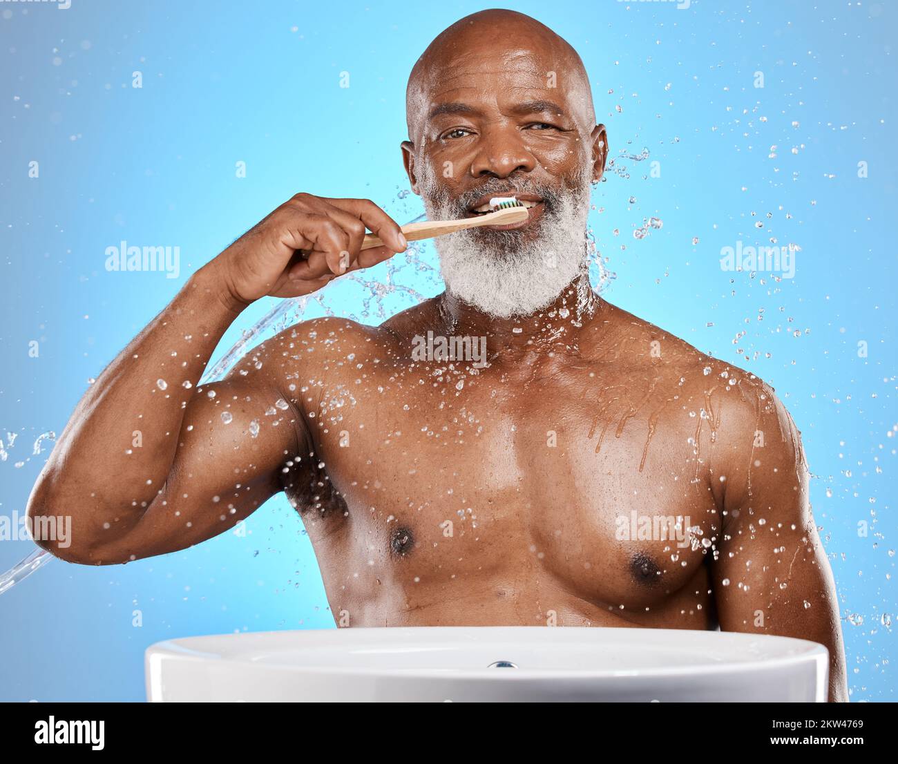 Dental, brushing teeth and black man with toothbrush for teeth, cleaning with toothpaste for fresh breath and healthy gums against blue background Stock Photo