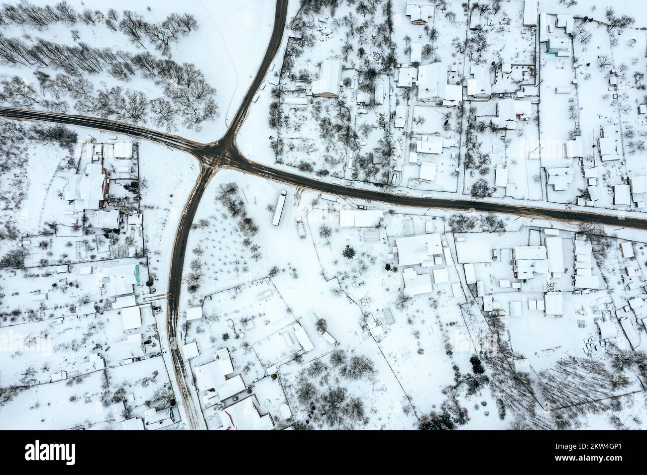 aerial drone photo looking down onto the rooftops of snow-covered suburban district Stock Photo