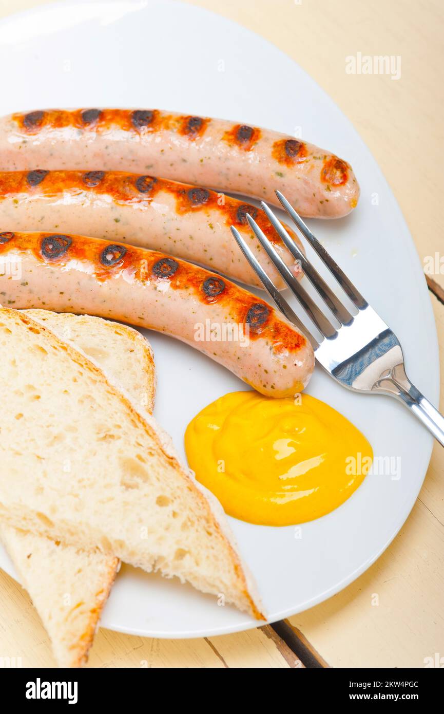 Traditional fresh German wurstel sausages grilled with yellow mustard Stock Photo