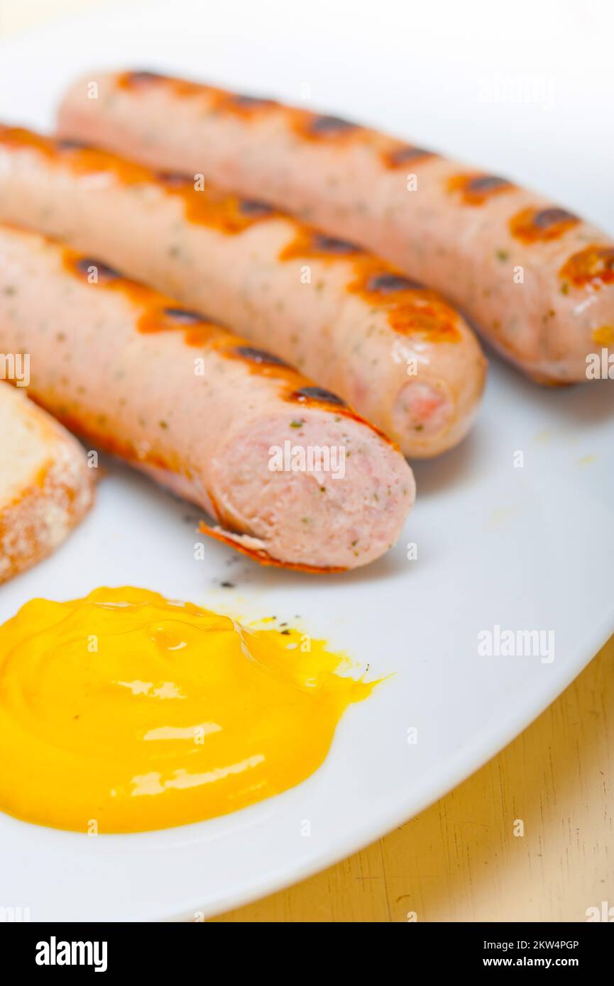 Traditional fresh German wurstel sausages grilled with yellow mustard Stock Photo