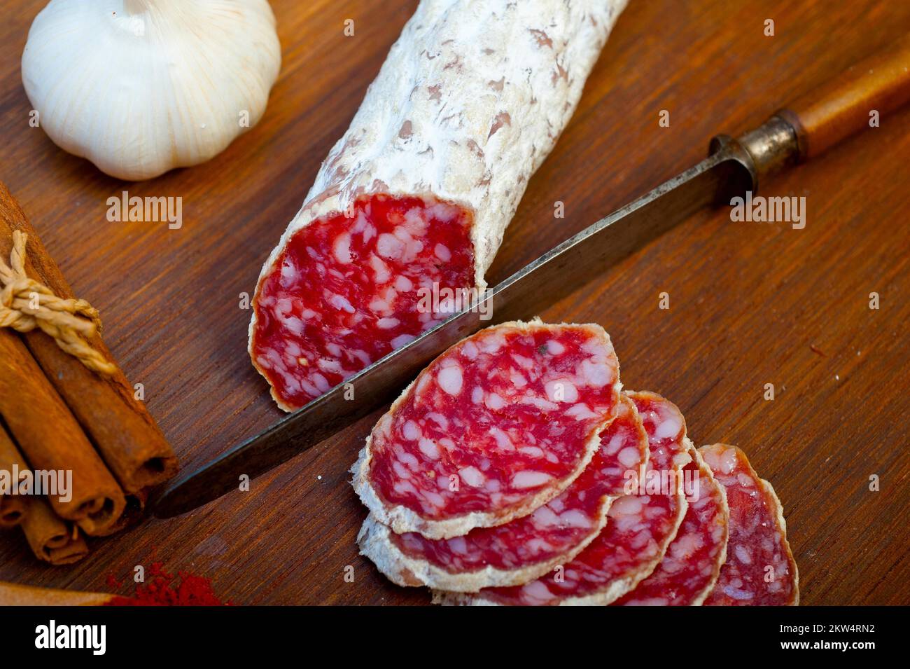 Traditional Italian salame cured sausage sliced on a wood board Stock Photo