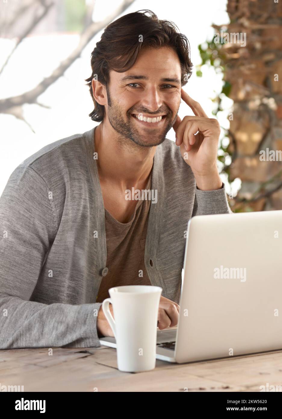 Hes always online first thing in the morning. a young man working on a laptop at home. Stock Photo