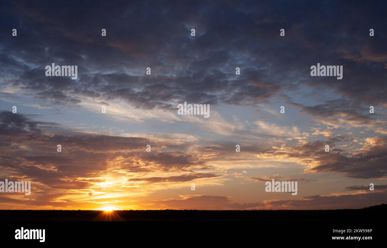 Sunset with multicolored clouds to the horizon Stock Photo