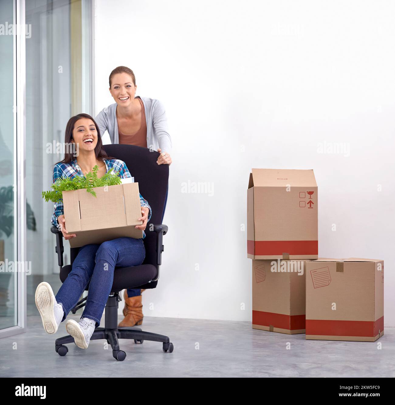 Showing her their new office space. two female entrepreneurs moving into a new office. Stock Photo