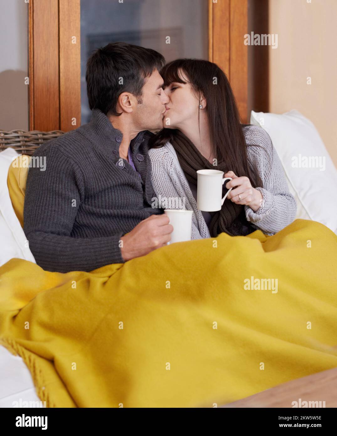 They have everything they could ever want. an affectionate couple wrapped in a blanket and