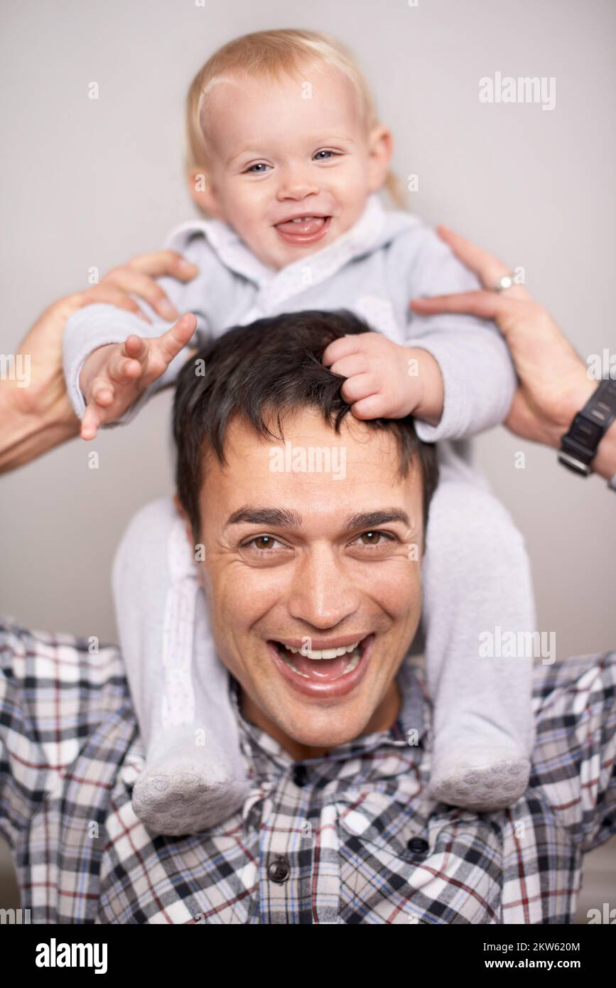 I will never let you fall, my dearest daughter...Portrait of a young father carrying his daughter on his shoulders. Stock Photo