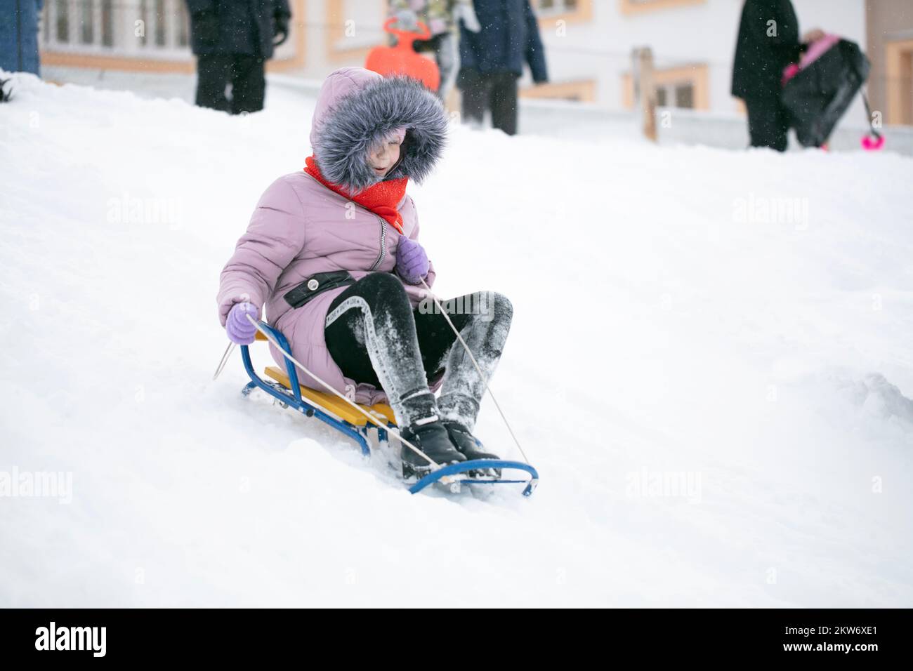 A girl warmly dressed sledding on a cold winter day Stock Photo - Alamy