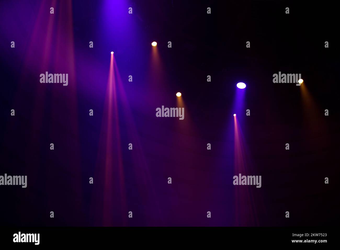 Purple beams of light from stage spotlights on a dark background Stock ...