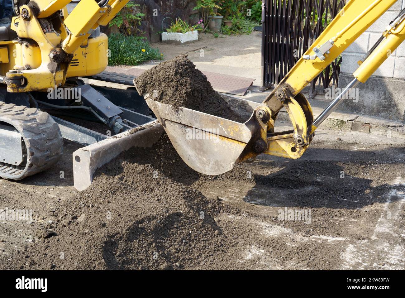 Repaving the road, The excavator is leveling gravel on the road, making a base for laying the asphalt. Stock Photo