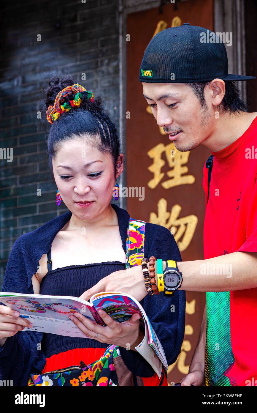 Asian tourist couple reading tour guide book, Hoi Quan Tue Thanh temple, Ho Chi Minh City, Vietnam Stock Photo
