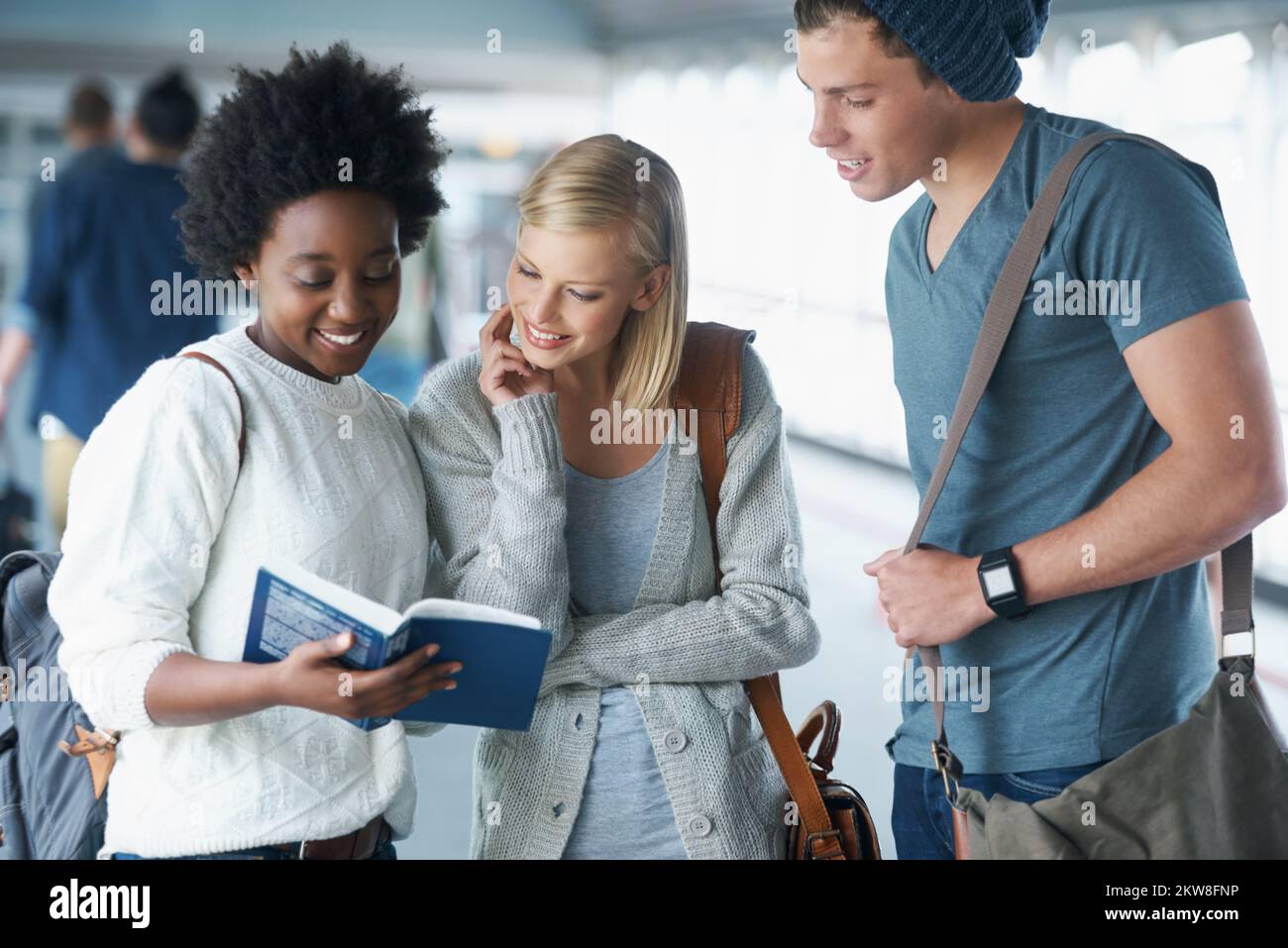 Fascinated and eager to learn. A group of college students looking at a book together. Stock Photo