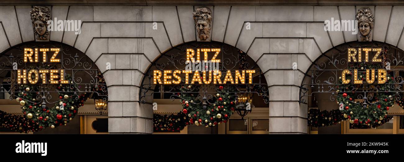 LONDON, UK - NOVEMBER 16, 2022:      Panorama vit of lit signs for Ritz Hotel, Ritz Restaurant and Ritz Club outside the Ritz building on Piccadilly, Stock Photo