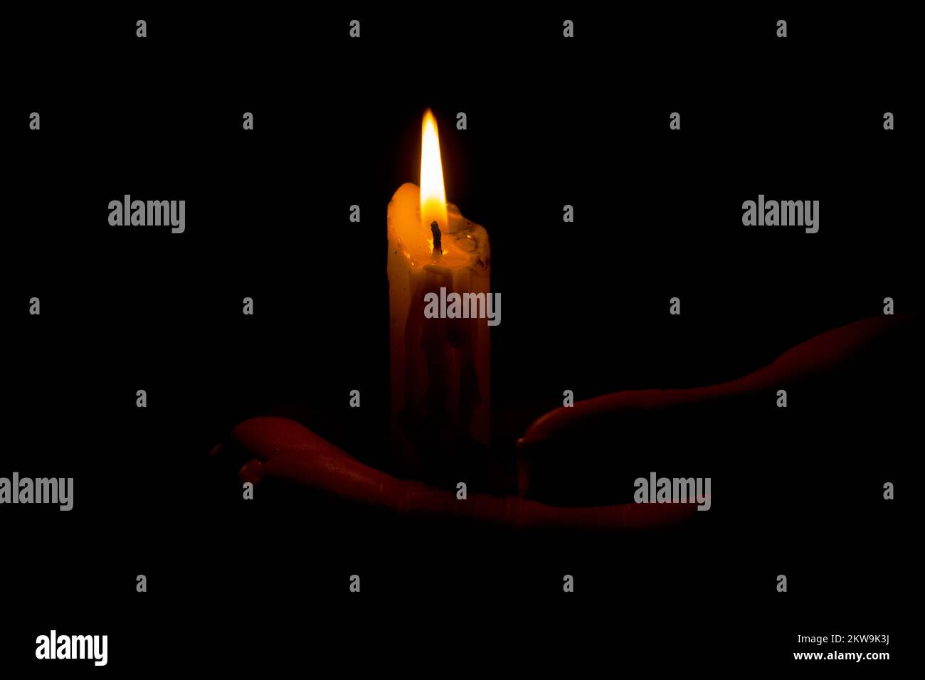 Girl holding a candle in the dark closeup, candlelight, religion and holidays Stock Photo