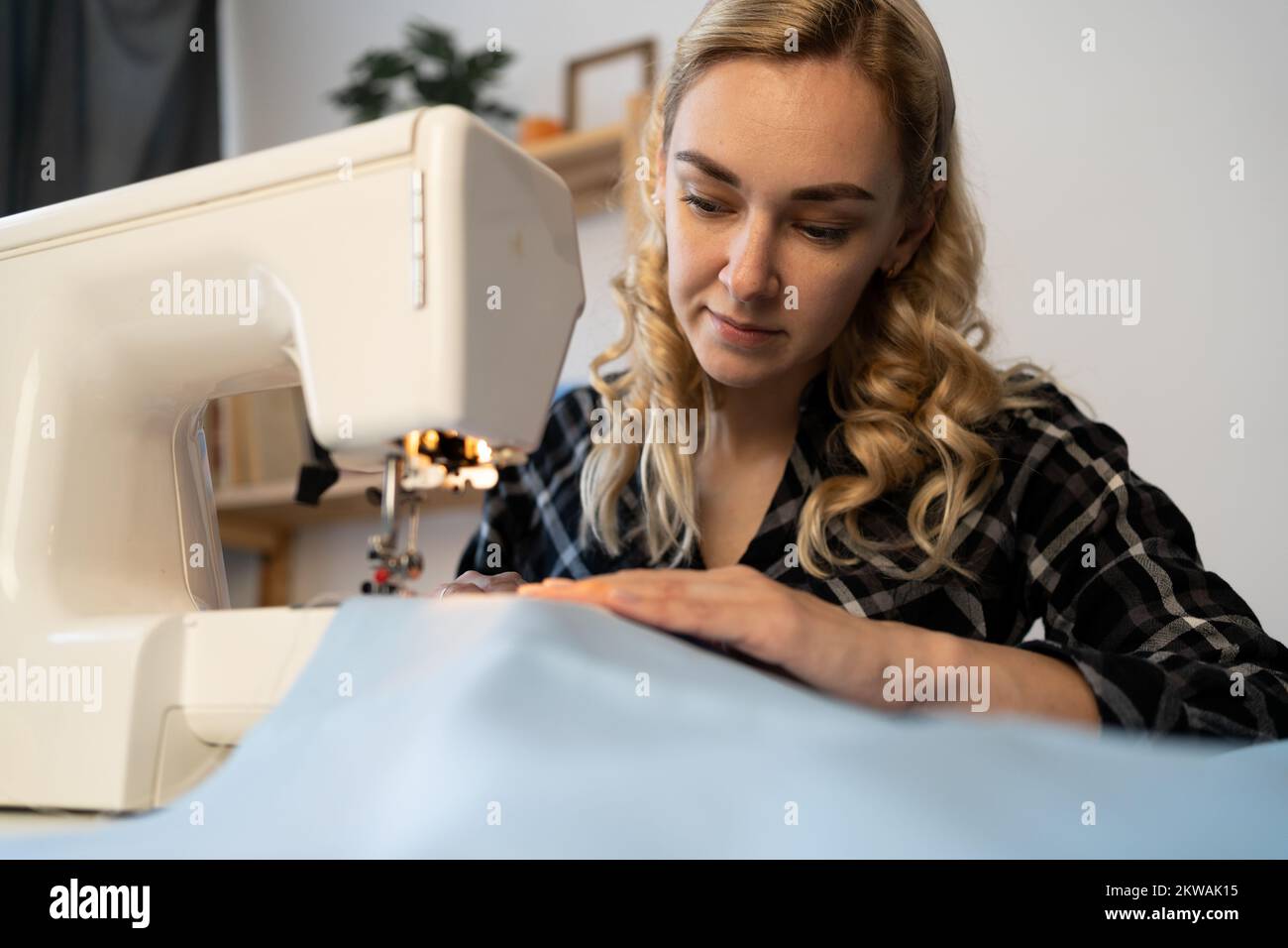 closeup portrait of dressmaker work on the sewing machine. Tailor making a garment in her