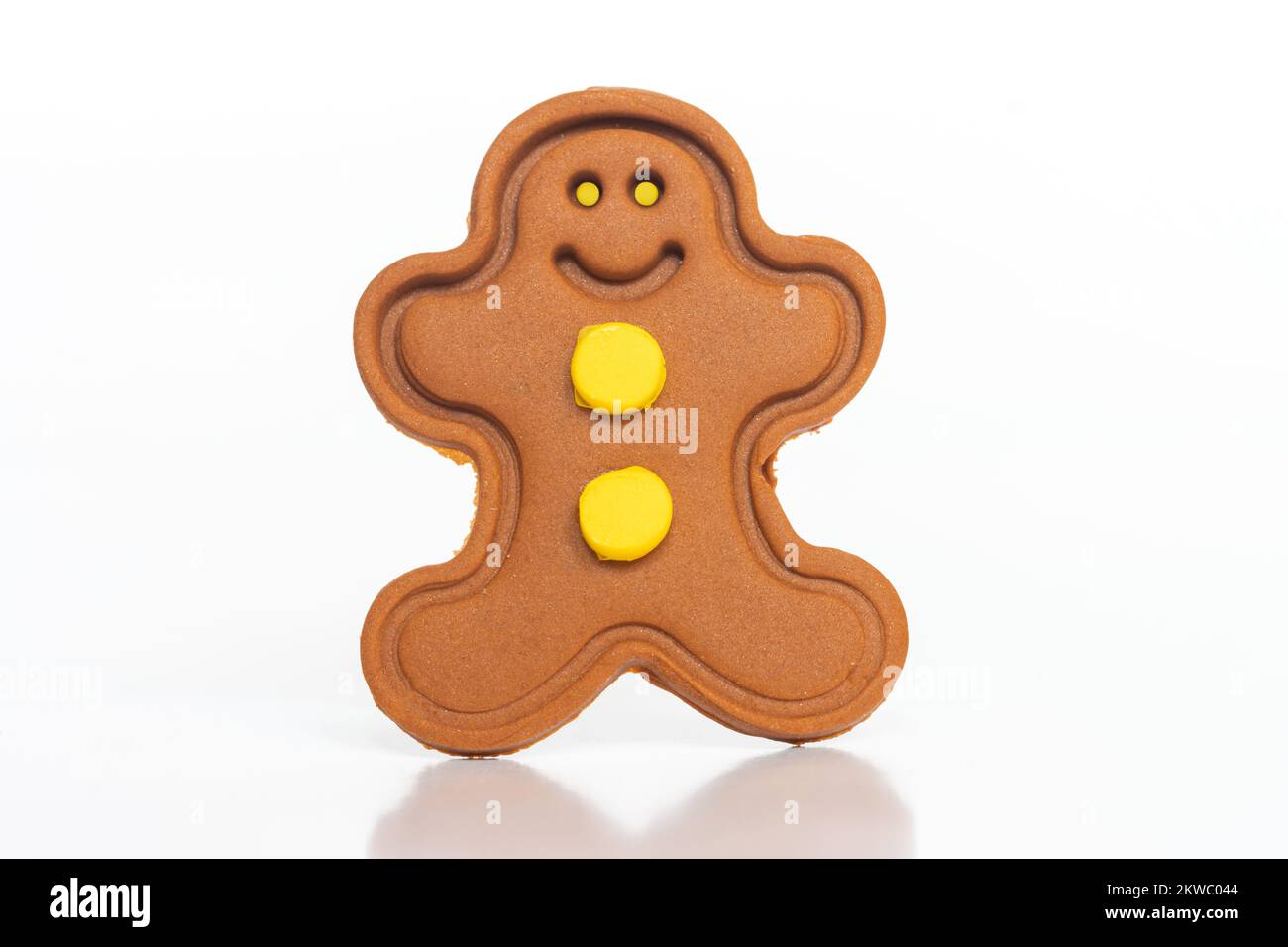 Gingerbread man figure with yellow eyes on a white background Stock Photo