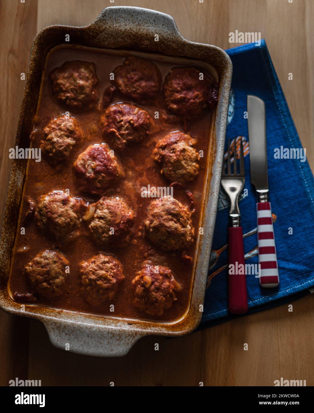 Meatballs with rice, baked in ceramic form in an oven with tomato paste
